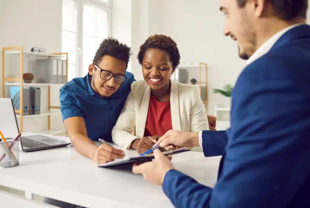 young couple signing home insurance papers at home