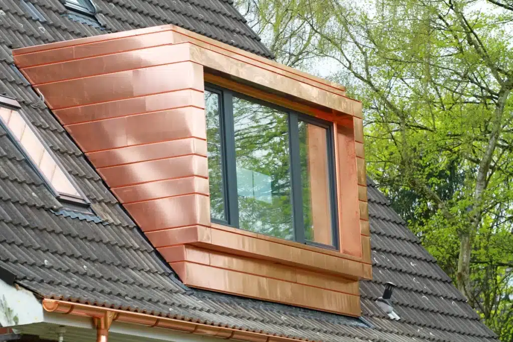 Metal shingle roof with copper gutter accents and gutter and copper roof dormer