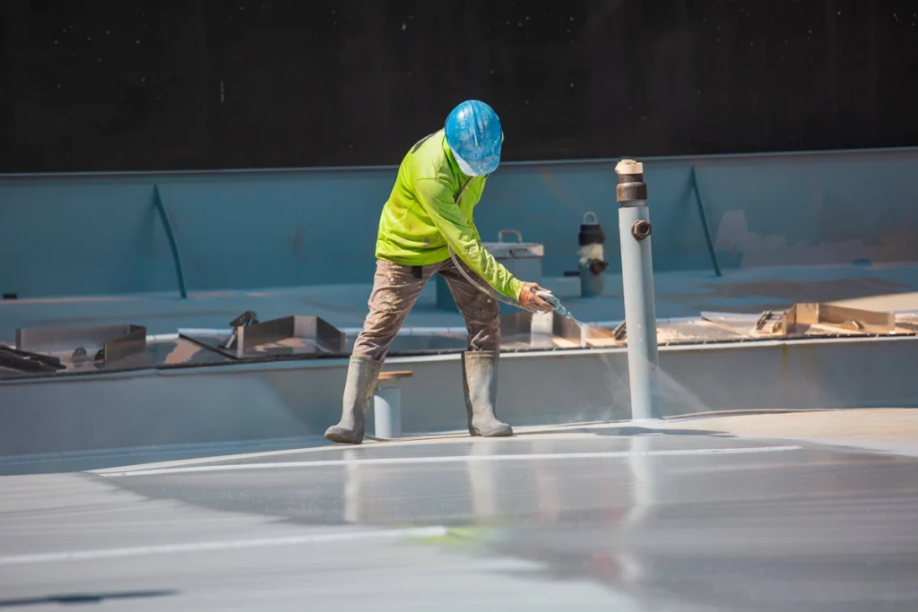 contractor installing spray on silicone roof coating