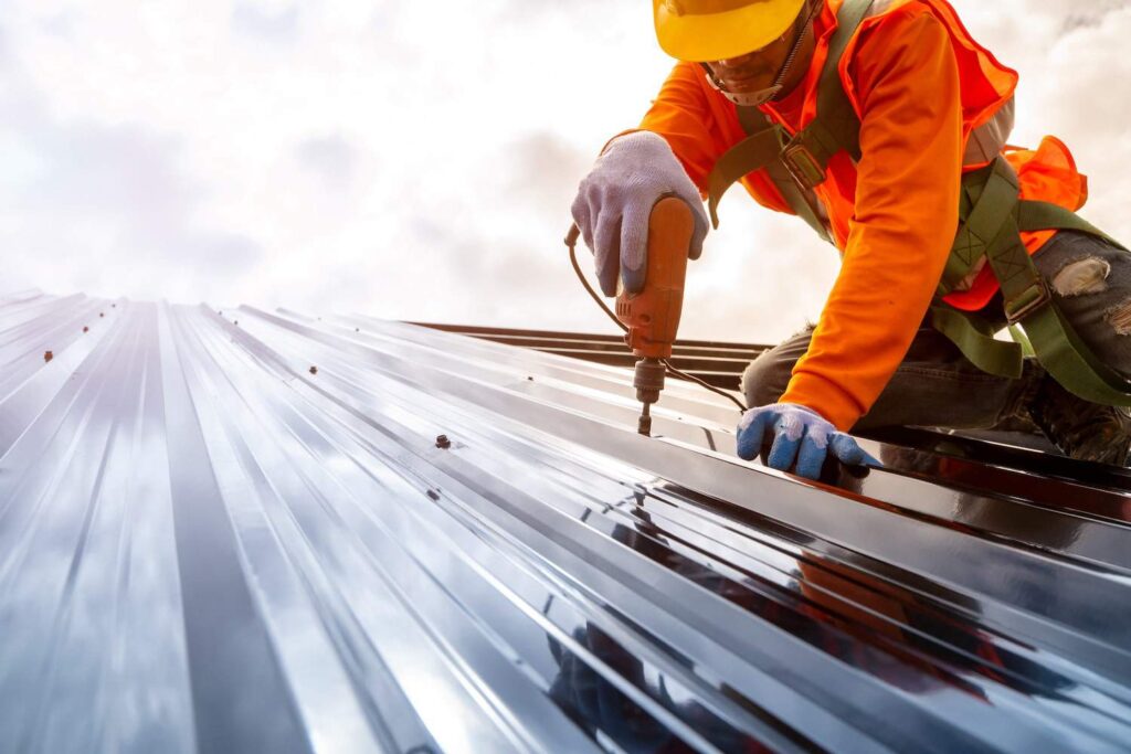 commercial roof maintenance man drilling down. metal roof