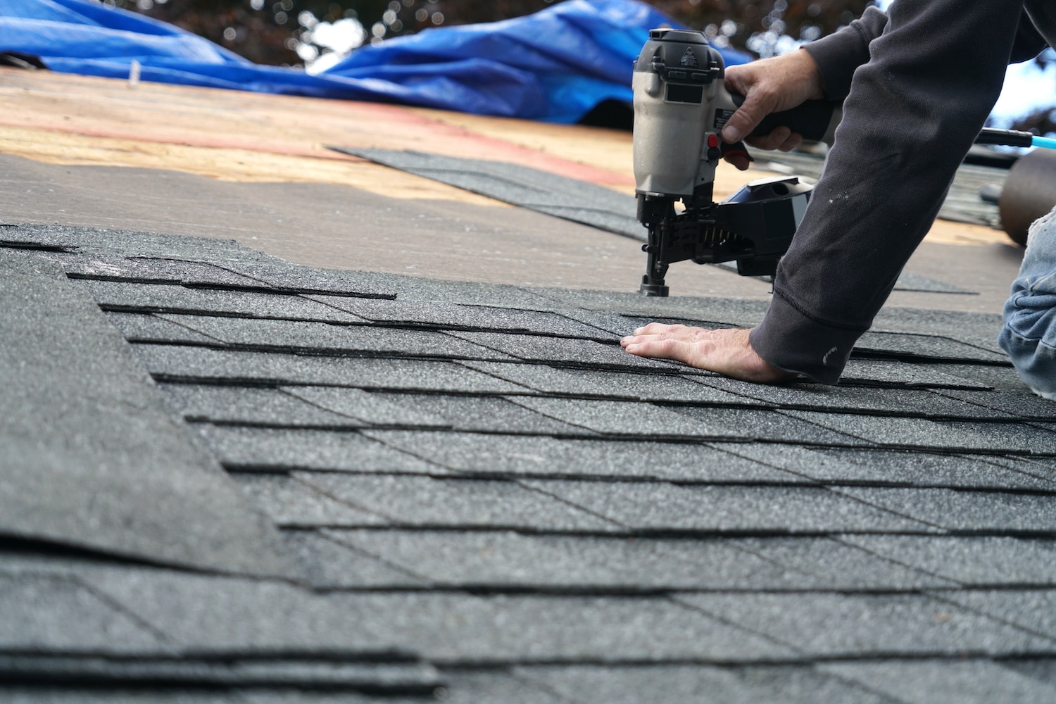how long does it take to replace a roof man using nail gun to install new asphalt shingles