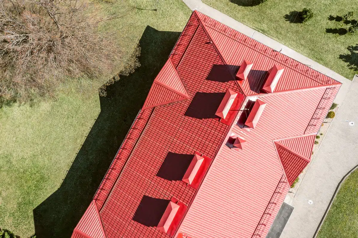 residential home with red metal roof and ventilation