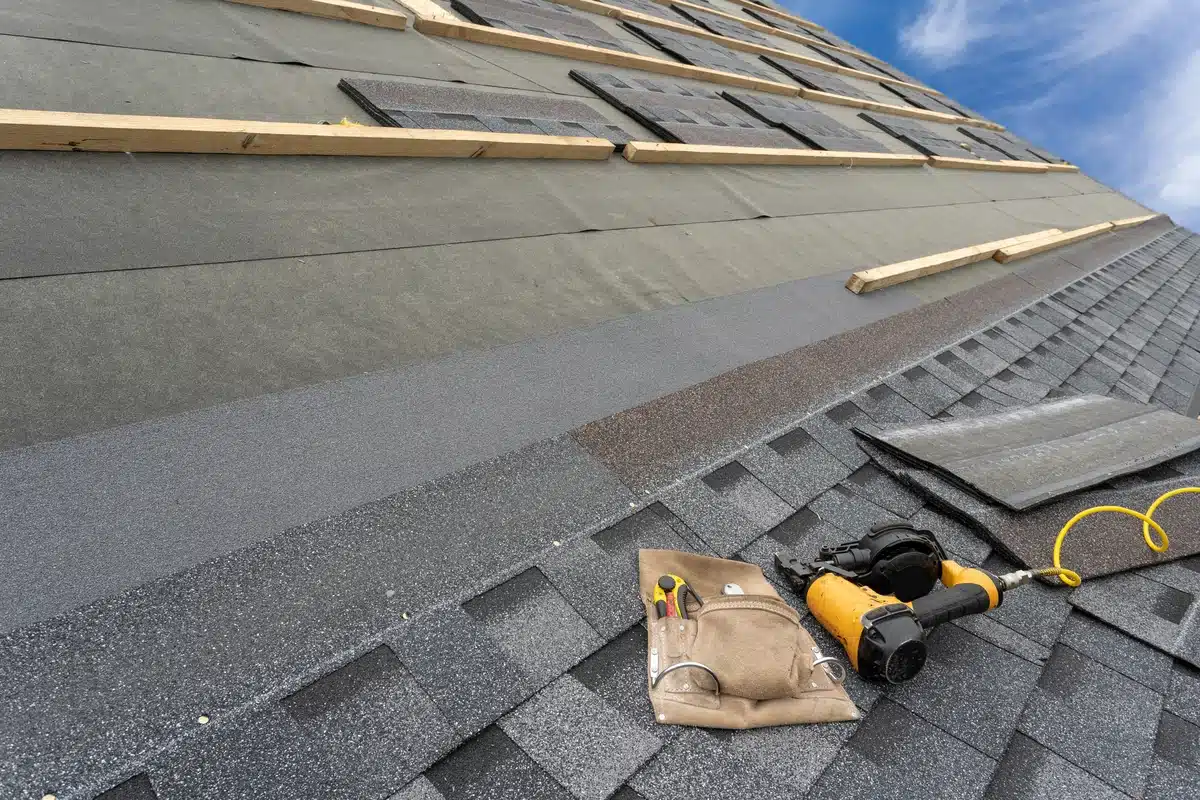 asphalt shingle roof with roofers tools