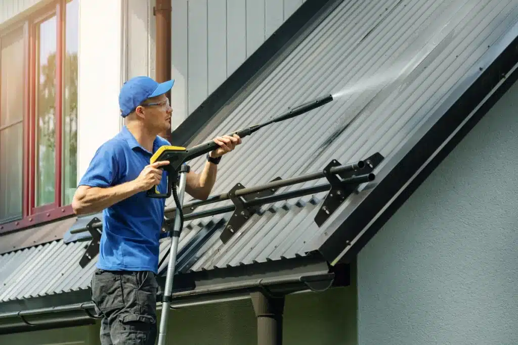 a roofer washes a metal roof