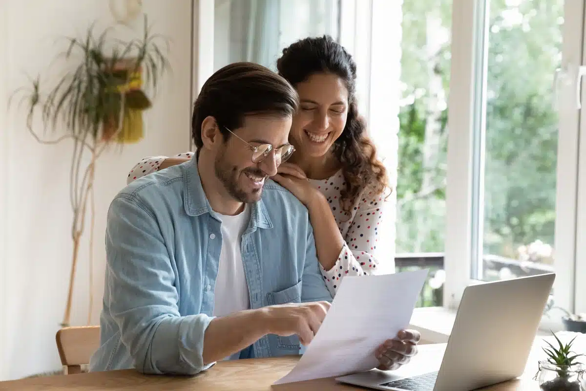 couple looks at a laptop and paper