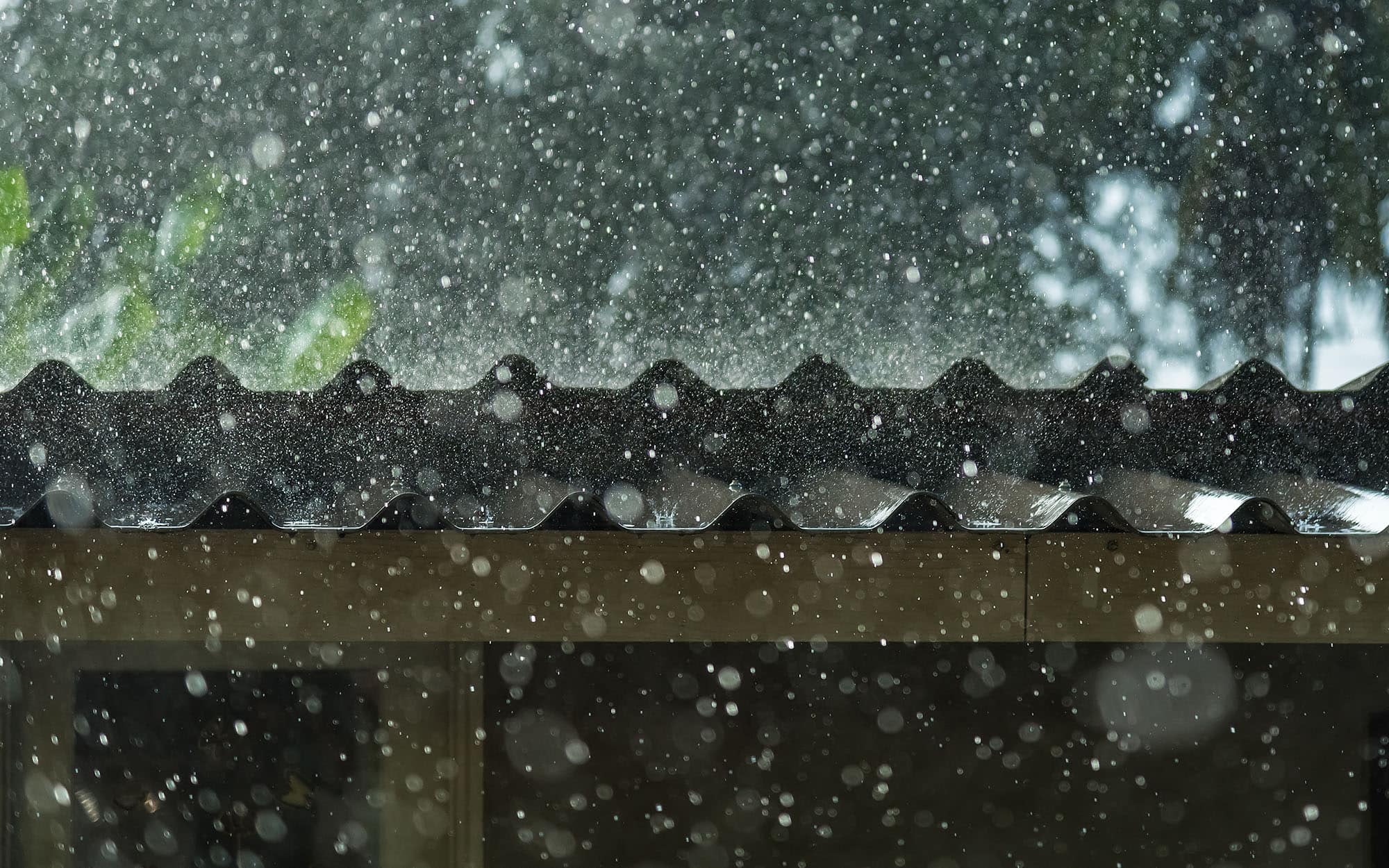 Side view of a roof with hail falling down on it